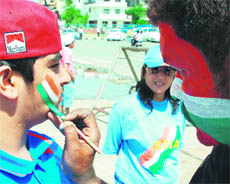 A cricket fan gets his face painted.