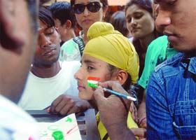 An Indian cricket fan paints his face as he gets ready for the match in New Delhi on Wednesday during the semi-final match between India and Pakistan in Mohali