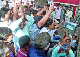 People watch the World Cup semi-final match between India and Pakistan on a TV set at the roadside near Connaught Place in New Delhi