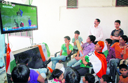People watch the live telecast of the Cricket World Cup semifinal between India and Pakistan at Mohali, in Jammu on Wednesday