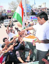 A cricket fan distributes sweets to celebrate Team Indias victory over Pakistan in the Cricket World Cup semifinal, in Karnal on Thursday. 