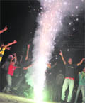 Youths burst crackers and dance after the victory of the INdian cricket team against Pakistan in Mohali 
