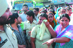 District president of the ASHA Workers Union Chhinder Pal Kaur wipes her tears after a private bus conductor slapped her while the protesting members of the union blocked the entrance to the bus stand in Bathinda 