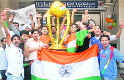 We want THE world cup: Excited youths pose with a replica of the Cricket World Cup Trophy ahead of the final match in Jalandhar