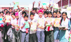 Students of Government Model School in PAU pose with free books given to them under the Sarva Siksha Abhiyan in Ludhiana