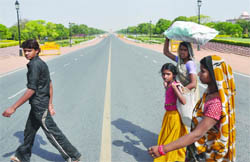 Labourers cross the almost deserted Rajpath during the India vs Sri Lanka final match of the World Cup tournament, in New Delhi