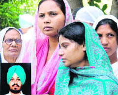 Relatives of Amritpal Singh (inset) in a pensive mood during their protest outside the MC office in Ludhiana