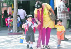 A woman asks her son (in uniform) about his first day experience in school in Ludhiana