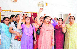 Members of the J&K Anganwari Workers and Helpers Union stage a protest in Jammu