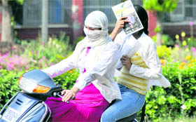 Rising mercury forces these two girls riding a scooter to cover their faces to escape the sun in Ludhiana on Tuesday.