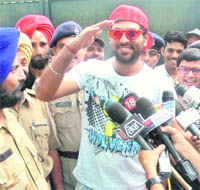 ricketer Yuvraj Singh (Man of the Series, World Cup 2011) salutes his fans while coming out from the Chandigarh airport