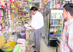 An official of the Health Department collects samples of kuttu flour at a kiryana shop in Hisar