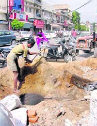 A labourer digs a spot in front of the college road market in Ludhiana. 