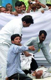 Activists attend to one of the supporters of Anna Hazare, who is also fasting unto death, after he fell down on Thursday, the third day of the indefinite hunger strike started by the social activist against corruption.
