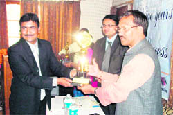 State Agriculture and Livestock Minister Trivendar Rawat presents award to CEO SS Pundir in Mussoorie.