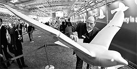 An engineer poses with the SmartBird, an ultralight model for flight, at the stand of FESTO at the industrial trade fair in Hanover on April 4, 2011.