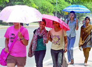 Girls hold parasols to save themselves from the rising heat in New Delhi.