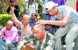 Members of the Uttarakhand Jan Sena get their heads tonsured in support of Anna Hazare, at the Gandhi Park, Dehradun, on Friday.