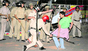 A policeman beats a cricket fan at the Clock Tower in Dehradun on Saturday night.