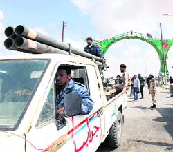 Libyan rebels at the Ajdabiyah western gate as they travel to the front line on Friday.