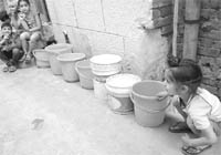 Children wait for their turn to fetch water in different areas of Patiala on Saturday. This is becoming a common scene in the city due to the shortage of water.