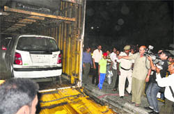 People have a look at the goods container that caught fire at Samrala Chowk in Ludhiana on Saturday.