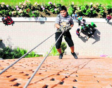 A boy takes part in an adventure camp at the KVM in Ludhiana on Saturday.