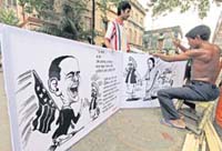 A worker makes a cartoon hoarding for the West Bengal Assembly election in Kolkata on Friday