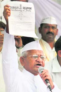 Hazare shows the gazette for the formation of the committee to draft the Lokpal Bill, in New Delhi on Saturday