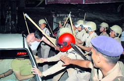 Policemen pull cricket fans out of car at the Clock Tower in Dehradun on the night of April 2