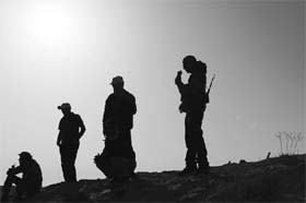 Rebel fighters silhouetted along the area to the east of Brega, Libya
