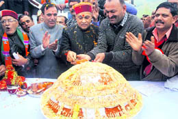 Prof P K Dhumal, Chief Minister, cuts a king-size 67 kg laddu to celebrate his 67th birthday at Pragatinagar near Shimla on Sunday