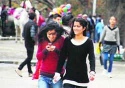 Girls enjoy a walk amid rain and strong wind on the Ridge in Shimla on Sunday