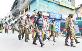 Security personnel patrol a closed market during a strike called by the JKLF in Srinagar on Sunday