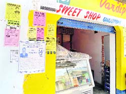 Posters of various parties pasted on a wall in a bid to attract voters next to a sweet shop at Gandli Morh village near Bisnah.