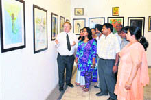 US artist Martin Victor (left) briefs visitors about his paintings at Artmosphere Gallery 