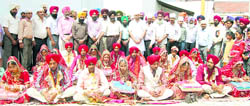 Eleven newly wedded couples after a mass wedding in Mandi Gobindhgarh on Sun