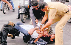 Another occupant of the Skoda (checked shirt, lying on the road) continues to grip the neck of a person who had come to the rescue of the girl. Policemen, who arrived on the scene within minutes, had a tough time trying to free the person from the tight grip.