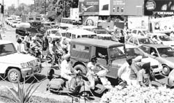 A harried lot of commuters make their way through traffic chaos at the Fountain chowk in Patiala.