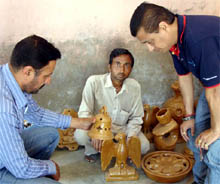 Heera Lal, an artisan, showing his handicraft items at Khuian Sarwar village.