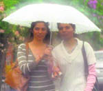 Two girls walk on a road as rain lashes Dehradun on Tuesday morning.
