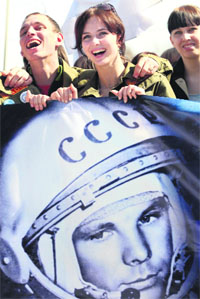 Students hold a portrait of first cosmonaut Yuri Gagarin during a meeting to commemorate his first flight to space in the city of Barnaul in Russias Altai region on Tuesday.