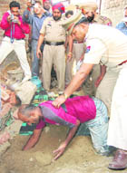 Police officials make accused Ashok Kumar dig out the body of the 5-year-old domestic help at the Shiv Nagar locality in Jalandhar on Wednesday.