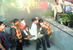 Hotel staff rescue a rickshaw-puller from the basement of the hotel where fire broke out in Jalandhar on Wednesday. 