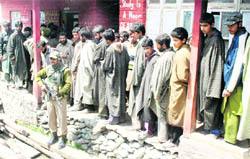 A CRPF personnel stands guard outside a polling station at Chattergul-Kangan on Wednesday.