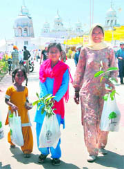 Devotees carry saplings given under the Nanhi Chhan programme at Takht Sri Damdama Sahib on Wednesday