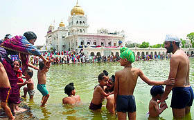 Sikh devotees take a dip in the holy sarovar at Gurudwara Bangla Sahib on Baisakhi festival in New Delhi on Thursday.