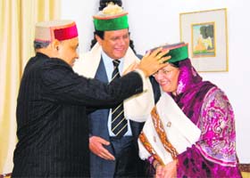 Chief Minister PK Dhumal presents a cap to Sajida Kayani at Oakover in Shimla on Thursday