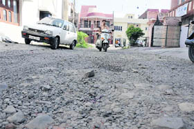 A scooterist has a tough time negotiating a dilapidated road in Sector 13 in Karnal.
