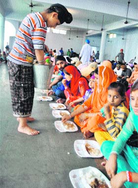 Devotees partake off langar on the occasion of Baisakhi festival at Gurdwara Tali Sahib in Jammu on Thursday